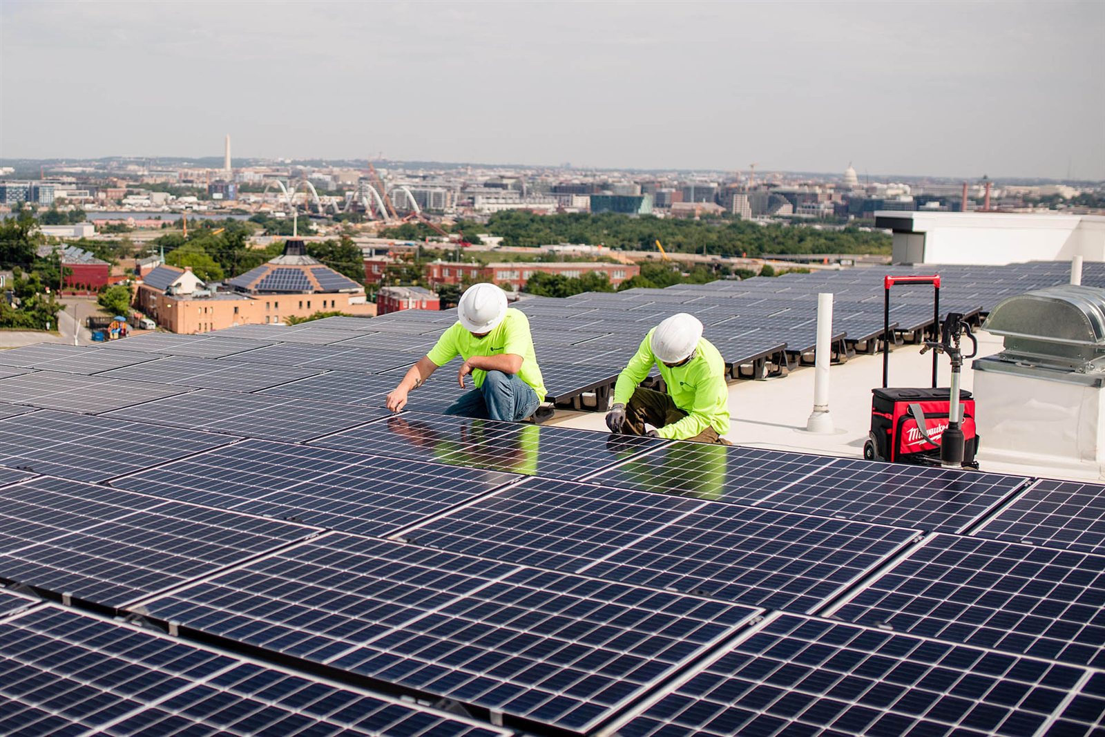 Solar installers working on a large commercial rooftop array